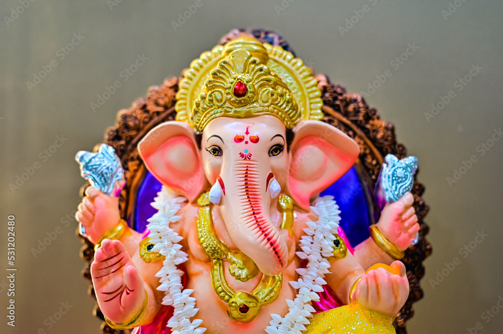 Hindu God Ganesha Close Up Elephant Face. Lovely Statue Of God. Colorful Lord Ganesha. Brown Background. Main Hindu God. Hinduism Religion and Culture.  