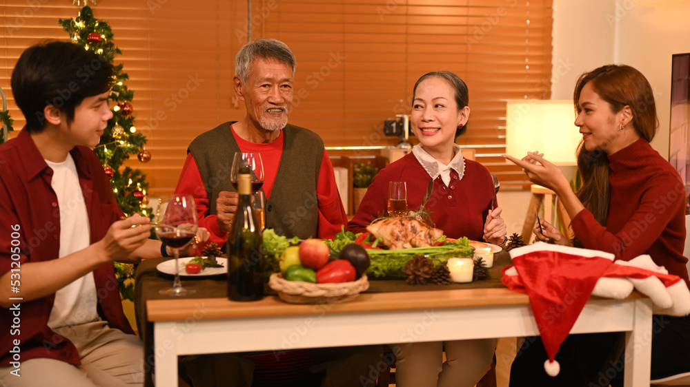 Joyful family talking and celebrating Christmas at dining table. Holidays and celebration concept Joyful family talking and celebrating Christmas at dining table. Holidays and celebration concept