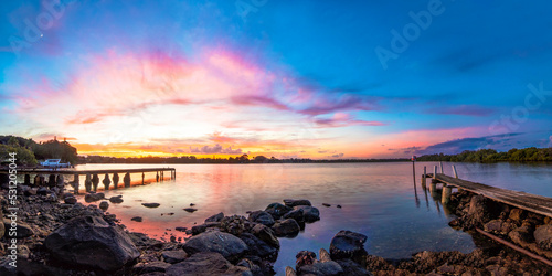 Vibrant colours of dawn, before sunrise, above a pier on Tweed River