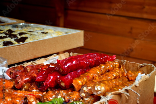 A close up on various colorful cakes, sweets, rolls, and other foodstuffs diplayed for sale on a small wooden stall seen on a sunny summer day during a medieval folklore fair or festival in Poland photo