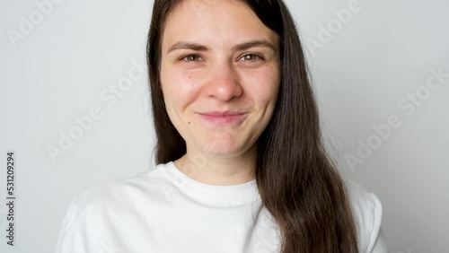 A woman chews a plaque indicator tablet on a white background.
