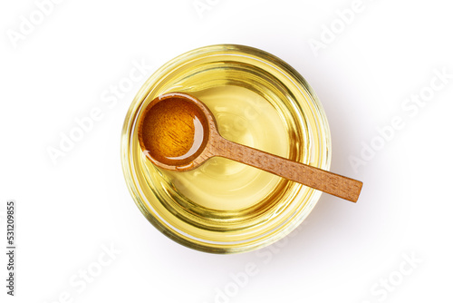 Soybean oil or vegetable cooking oil in glass bowl with wooden spoon isolated on white background with clipping path. photo