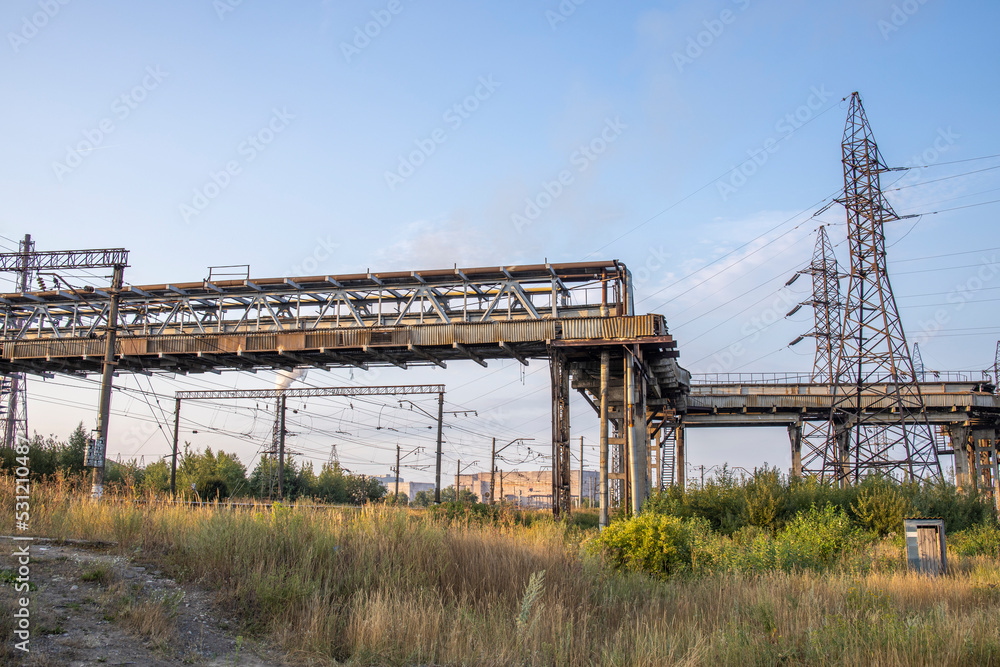 industrial landscape with heavy pollution produced by a large factory. Chemical plant. Pipes on the territory of the plant. power lines.