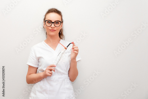 Portrait of a smiling orthopedist woman with a pedicure tool for correction ingrown nail in her hands. The concept of podology, chiropody and podiatry photo