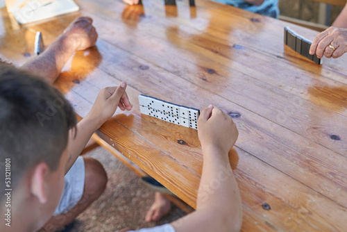 A family playing domino game in a wooden table