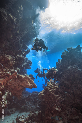 Divers explore the coral reef near the cave.