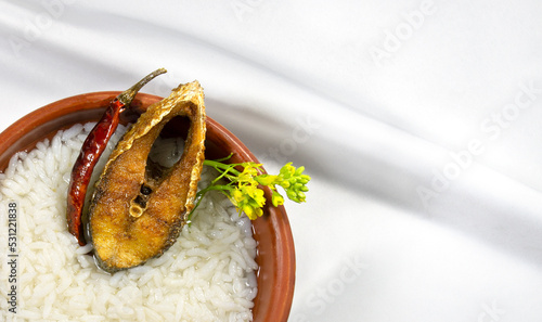 ilish panta Bengali new year festive dish. Boishakh panta ilish with green chilli and onion. Panta bhat is popular among Bengali's in India and Bangladesh. into clay plate seving bowl shanki or sanki