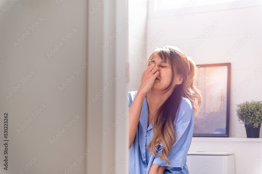 asian woman having stomach ache pain in toilet. ill painful adult unhappy woman desperate from smelly nasty urine or poop. sick unpleasant female weak person sitting using toilet seat urinate in pain asian woman having stomach ache pain in toilet. ill painful adult unhappy woman desperate from smelly nasty urine or poop. sick unpleasant female weak person sitting using toilet seat urinate in pain