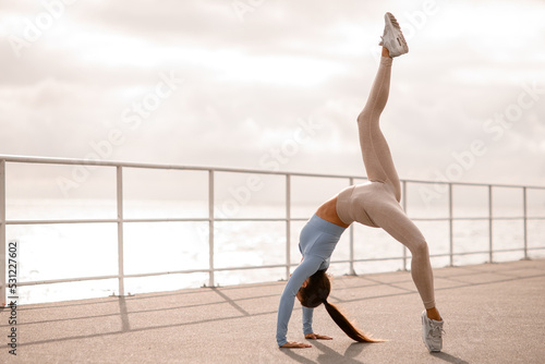 beautiful view of flexible woman with raised leg stretching for training body flexibility