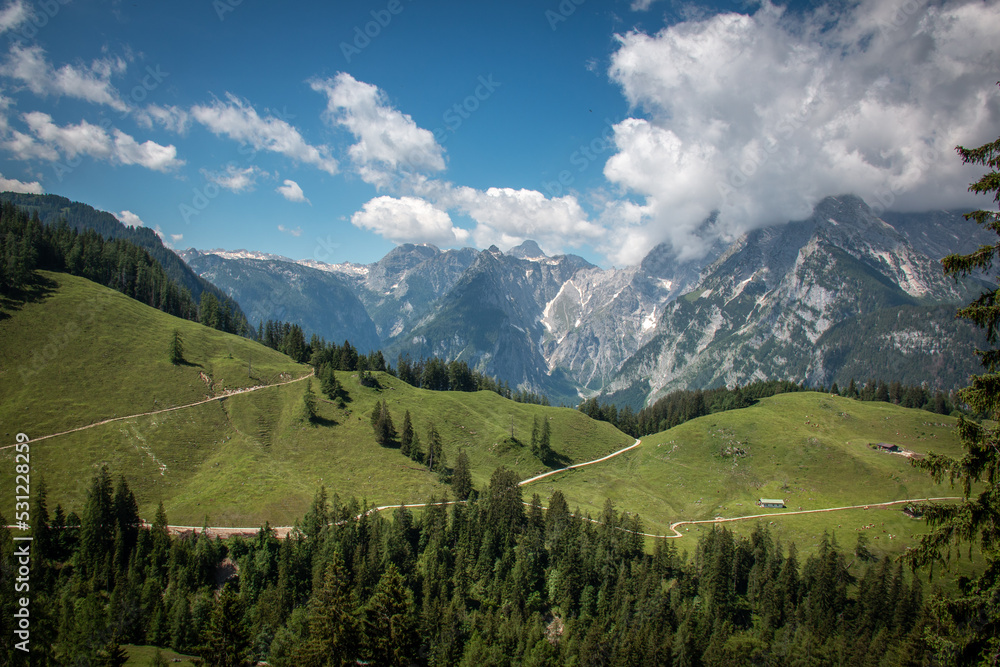 Fototapeta premium Berglandschaft mit Blick zur wolkenverhangenen Watzmannfrau und Watzmann am Hochbahnweg auf dem Jenner