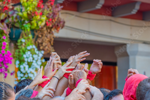 CAMBRILS, SPAIN - SEPTEMBER 04.2022: Hands at a Castells Performance, a castell is a human tower built traditionally in festivals within Tarragona photo