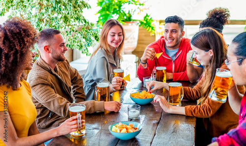 Photography group of friends celebrating happy hour drinking beers at bar restaurant indoor having fun together