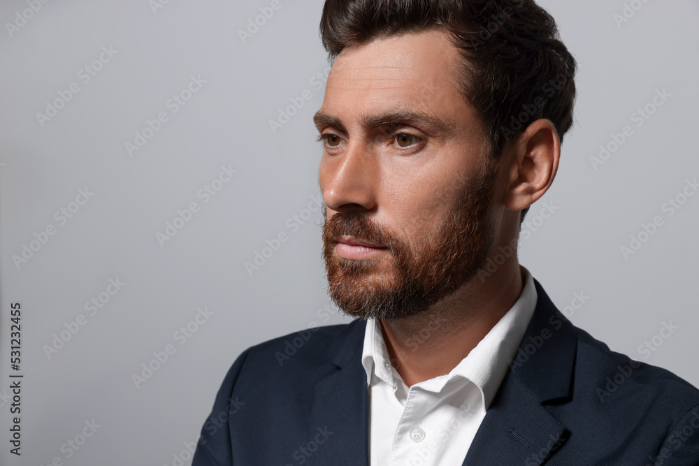 Handsome bearded man in suit on light grey background. Space for text Handsome bearded man in suit on light grey background. Space for text