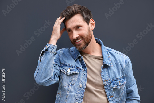 Portrait of smiling handsome bearded man on grey background © New Africa