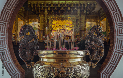 Metal dragons sculpture decorate on golden incense burner at Wat thamma katanyu or Tham Katanya Shrine Foundation (Sian Lor Tai Tian Gong). Incense burning in incense burner, Selective focus. photo