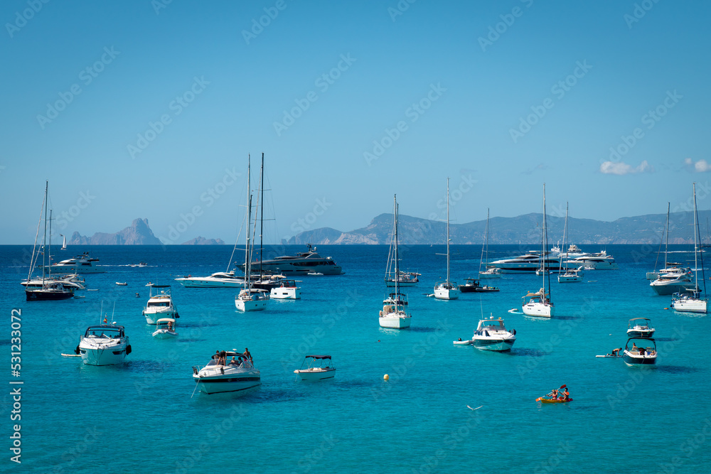 Boats anchored in Cala Saona with Es Vedra in the background