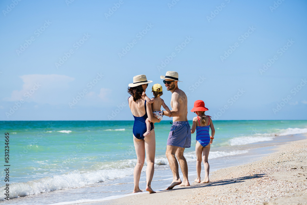 Happy young family walk at sea beach