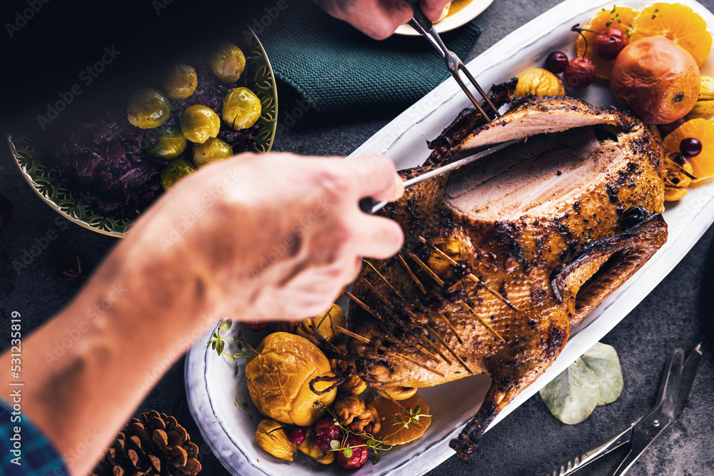 Christmas roast duck served on a festive table.man cuts the duck breast
