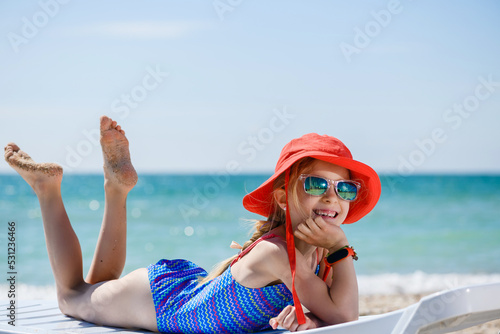 Happy little girl lay at sea beach