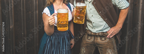 Print op canvas Oktoberfest, woman and man in Bavarian costume with beer mugs