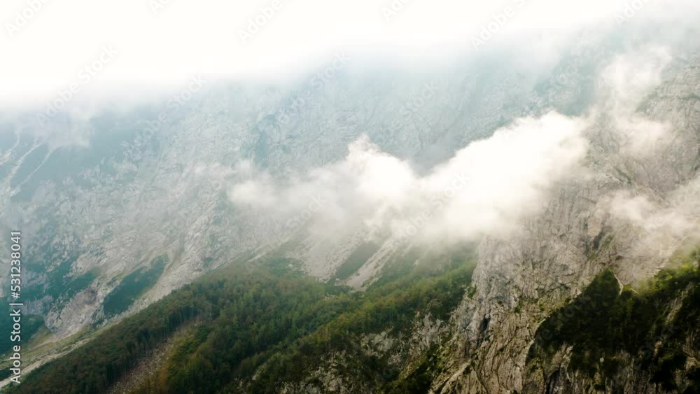 Aerial Slow Push In Shot Of Clouds Which Shape is Similar to Country Slovenia That Touches the Edge of the Mountain With Forest And Mist in The Background. Aerial Slow Push In Shot Of Clouds Which Shape is Similar to Country Slovenia That Touches the Edge of the Mountain With Forest And Mist in The Background.