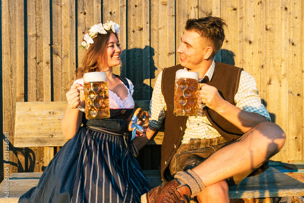Obraz premium Oktoberfest, woman and man in Bavarian costume with beer mugs
