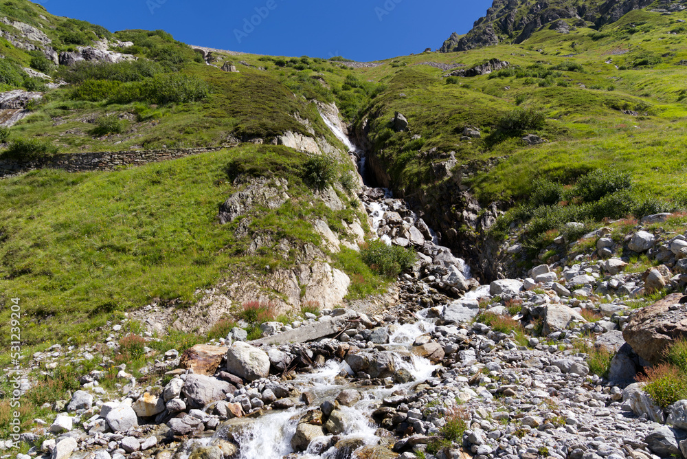 Swiss mountain pass Sustenpass with meadow and mountain river on a sunny summer day. Photo taken July 13th, 2022, Susten Pass, Switzerland.