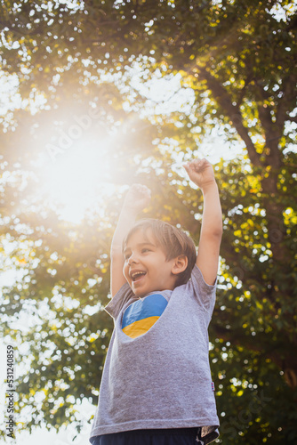 child hands up and smiling. Sunny day in park. Happy childhood.