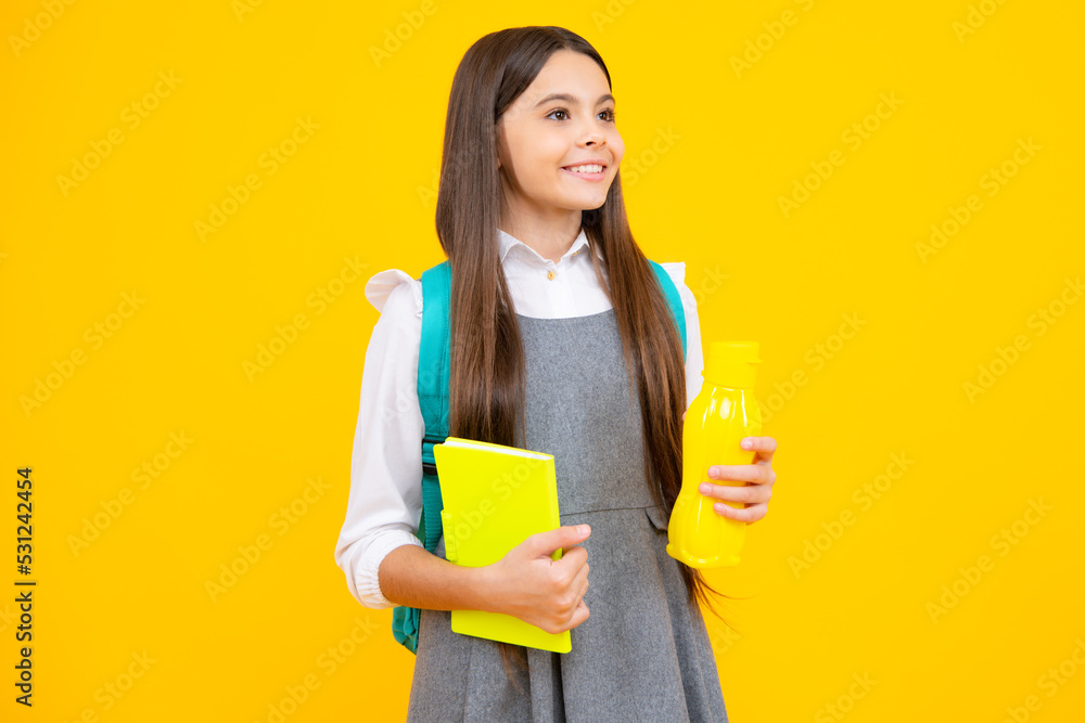 Teenager schoolgirl with backpack holding water bottle isolated on yellow background. Back to school concept. Healthy teen child. Teenager schoolgirl with backpack holding water bottle isolated on yellow background. Back to school concept. Healthy teen child.