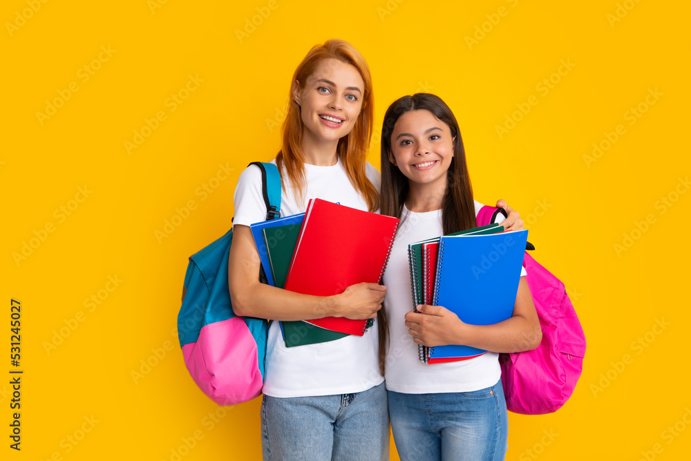 Back to school. Mother and daughter teen girl in with backpack. Teenagers students on yellow isolated background. Mom and child go school. Back to school. Mother and daughter teen girl in with backpack. Teenagers students on yellow isolated background. Mom and child go school.
