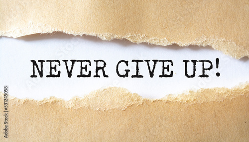 NEVER GIVE UP written under torn paper.