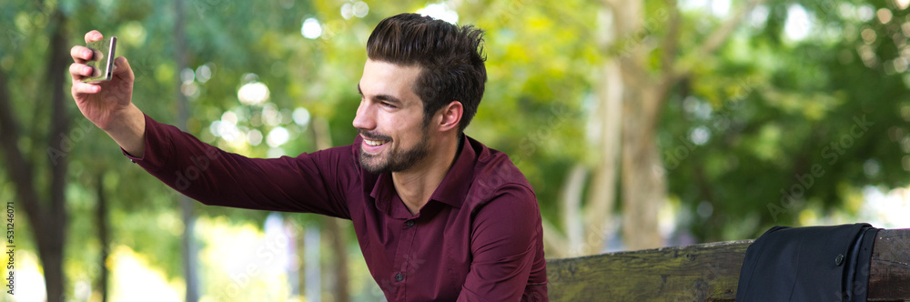 Young smiling businessman taking selfie in the spring park Young smiling businessman taking selfie in the spring park