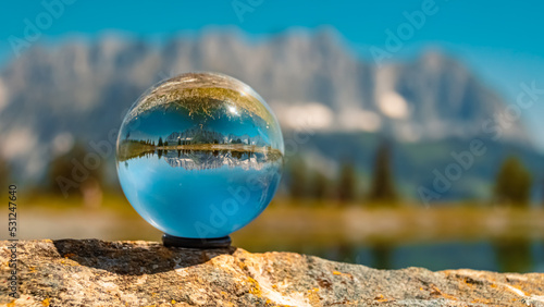 Crystal ball alpine landscape shot with reflections in a lake at the famous Astberg summit  Going  Wilder Kaiser  Tyrol  Austria