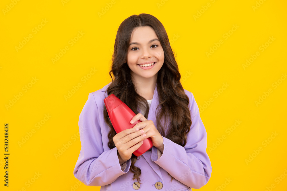 Child teen girl with shampoos conditioners and shower gel. Long hair care of teenager. Presenting cosmetic product, shampoo bottle. Happy teenager, positive and smiling emotions of teen girl. Child teen girl with shampoos conditioners and shower gel. Long hair care of teenager. Presenting cosmetic product, shampoo bottle. Happy teenager, positive and smiling emotions of teen girl.