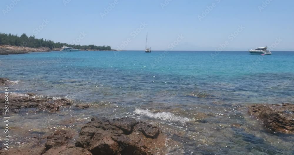 Seascape with sailboat at beautiful bay, pleasure of sailing. Clear blue sky on a sunny day. View from sea water level. Summer travel holidays concept. Slow motion 4K footage. Seascape with sailboat at beautiful bay, pleasure of sailing. Clear blue sky on a sunny day. View from sea water level. Summer travel holidays concept. Slow motion 4K footage.