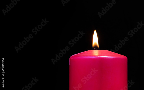 Copy space to the left of a burning candle