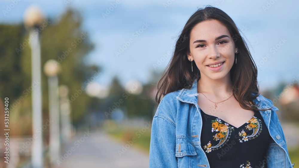 Portrait of a cheerful girl in a denim jacket at night in the city. Portrait of a cheerful girl in a denim jacket at night in the city.