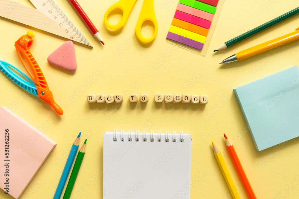 Back to school background. School accessories on a yellow background. Wooden blocks with letters Back to school background. School accessories on a yellow background. Wooden blocks with letters
