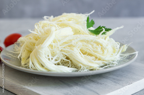 Turkish traditional homemade checil or string cheese on plate, healthy dairy product