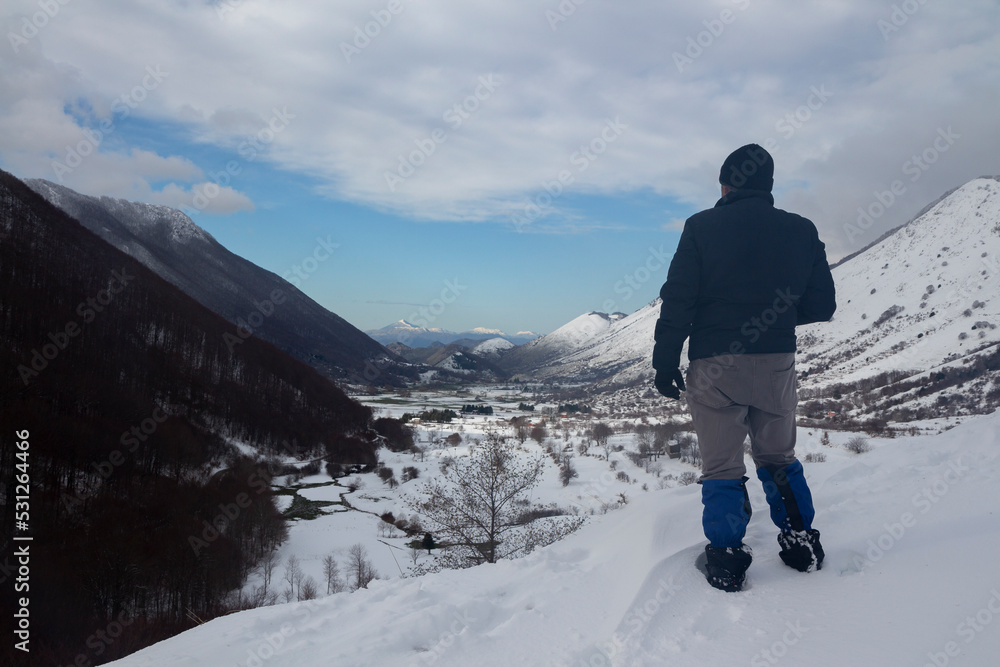 hiker with the letino valley with snow