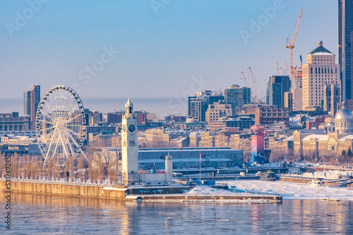 Winter view on the big wheel, the clock tower and the old port of Montreal early in the morning from Jacques Cartier bridge (Quebec, Canada) © Pernelle Voyage