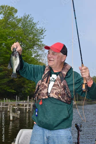 An angler with a crappie caught with a flyrod