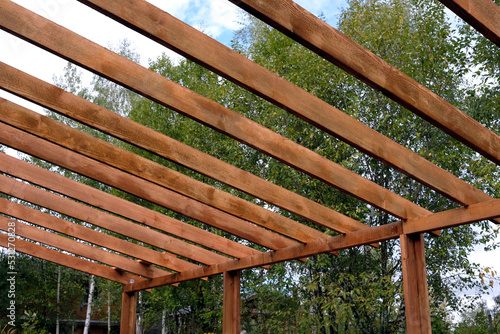 The process of building a wooden canopy from brown boards in the rural place in summer day photo