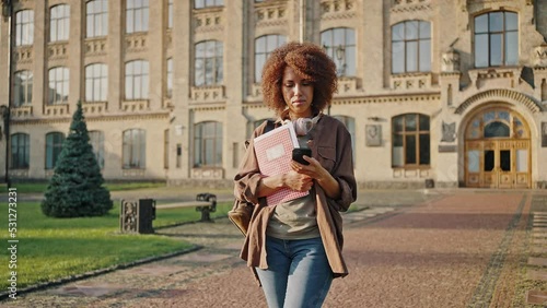 African American woman holds exercise book standing on road photo