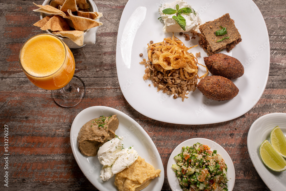 Assorted Middle Eastern dishes, Arabic food. Tabbouleh salad, babaganush, hummus, Labneh Yogurt cheese, quark cheese, pita bread, Fried Kibbeh and Mujaddara . Arabic cuisine. Lebanese food Assorted Middle Eastern dishes, Arabic food. Tabbouleh salad, babaganush, hummus, Labneh Yogurt cheese, quark cheese, pita bread, Fried Kibbeh and Mujaddara . Arabic cuisine. Lebanese food
