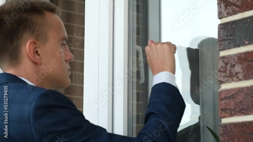Man in a business suit knocking on the window, rear view