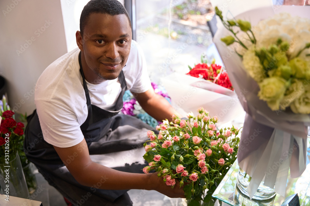 Man squatting with a bouquet of hands Man squatting with a bouquet of hands