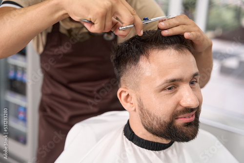 Pleasant guy having a fresh haircut at modern hair salon