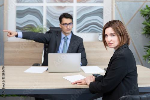 Foto Shocked female office worker surprising because of her angry boss fired her and