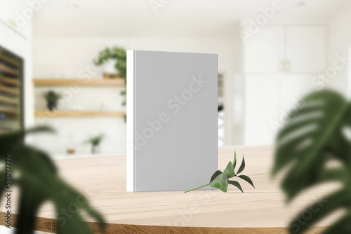 Clean minimal photo book 5.5x8.5 mockup standing on top table with vase